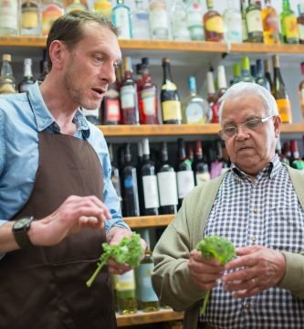 a man and a clerk holding lettuce leaves